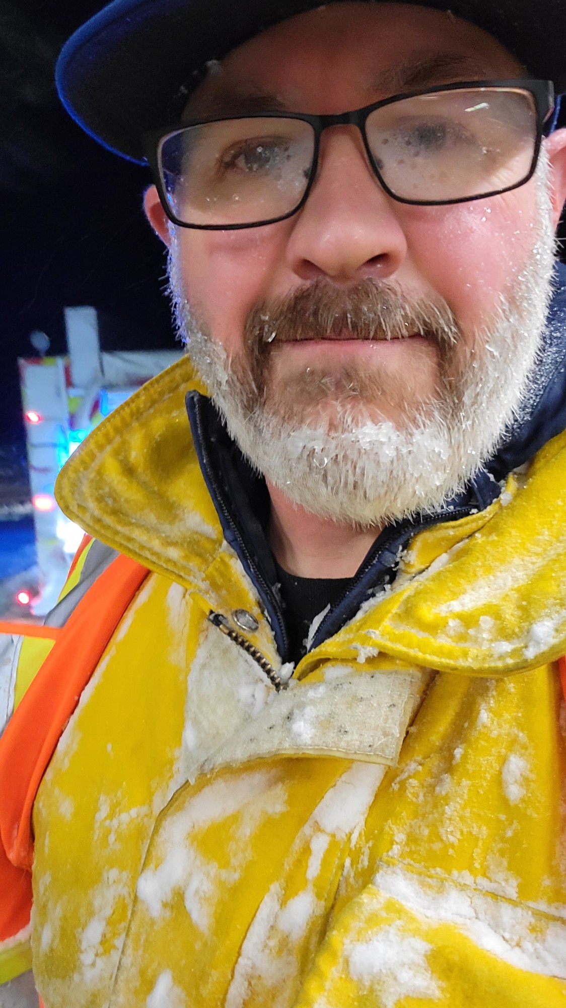 Travis McCormack in turnout gear, frost on beard and glasses, during a winter night call