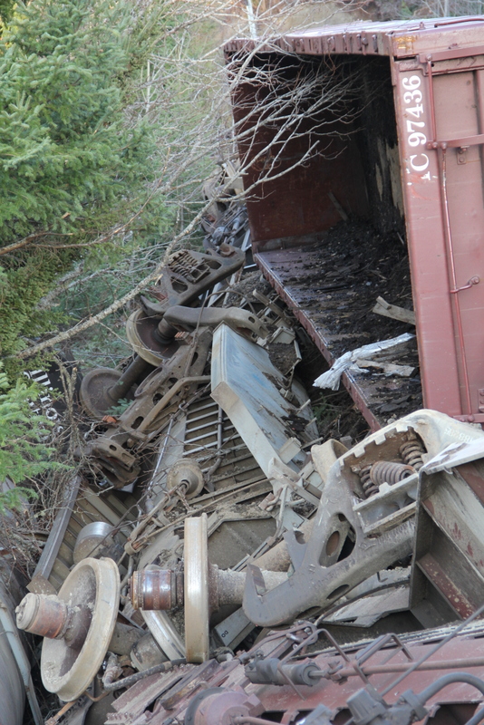 Close view of a derailed boxcar and tangled bogies and wheels