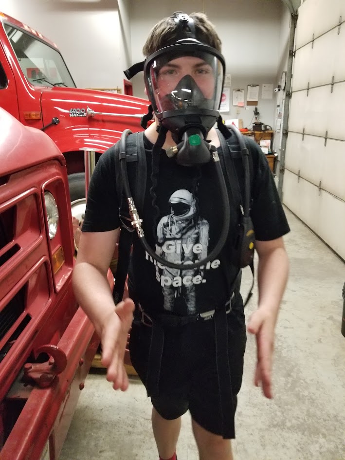 Member wearing an SCBA facepiece and harness in the apparatus bay